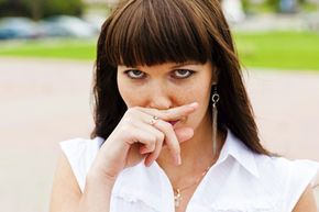 A woman applying pressure to her upper lip