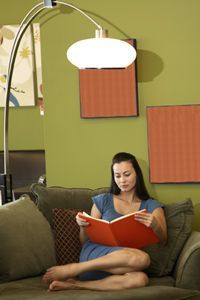 A woman reading under a lamp