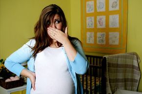 A pregnant woman covering her nose