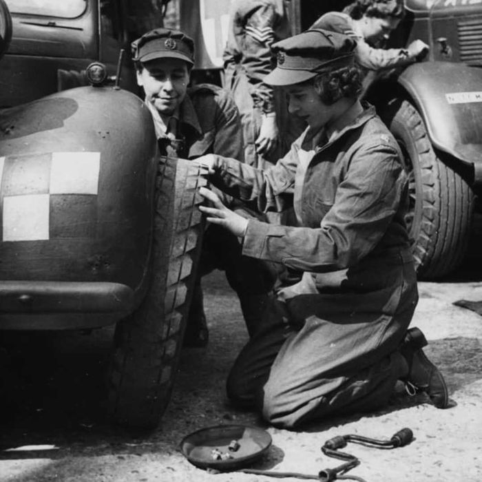 Princess Elizabeth changing a vehicle's tire while training as an ATS Officer during World War II in April 1945.