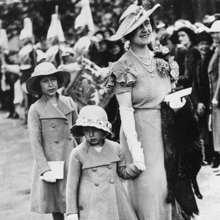 Queen consort Elizabeth holds Princess Margaret's hand while Princess Elizabeth follows, in 1936.