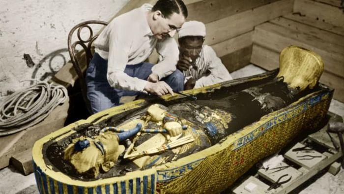 English Egyptologist Howard Carter stands beside the golden sarcophagus of King Tut in Egypt, 1923.