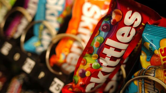 Bags of Skittles inside a vending machine.