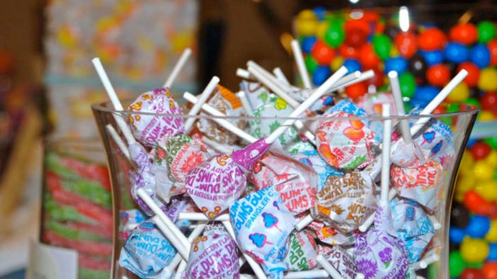 A jar filled with Dum Dums lollipops.
