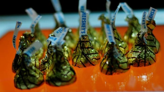 Hershey Kisses placed on an orange table.