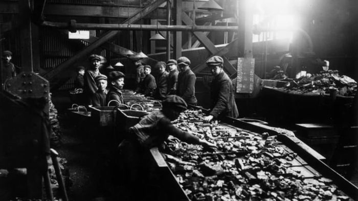 Young boys laboring in the coal troughs of South Wales mines, circa 1910.