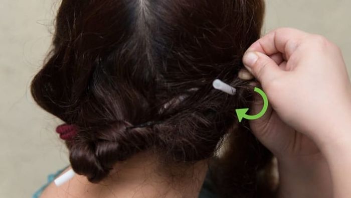 Someone curling their hair with straws.