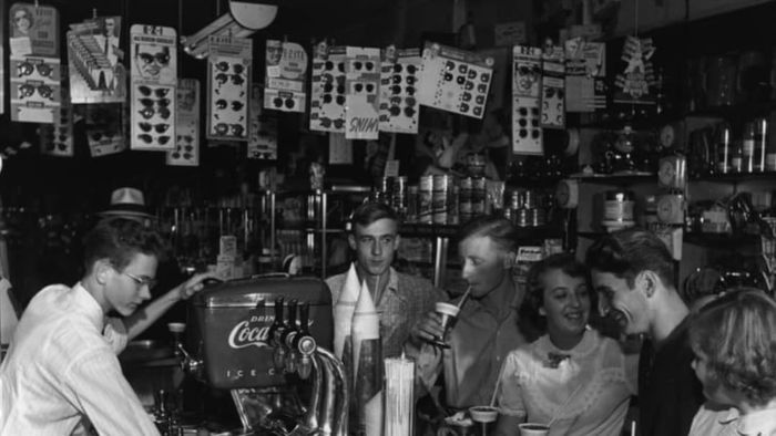 In 1950, a soda jerk prepares sweet beverages at a drugstore's soda fountain.