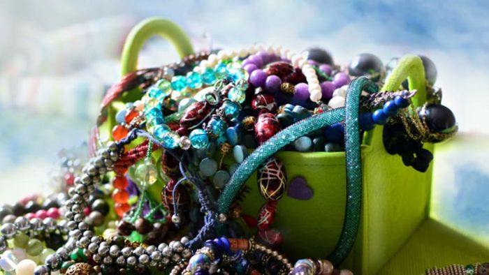 A jewelry box filled with knotted necklaces.