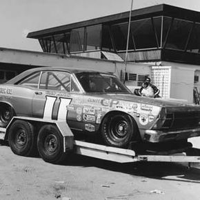 A Ford Fairlane being transported on an open trailer