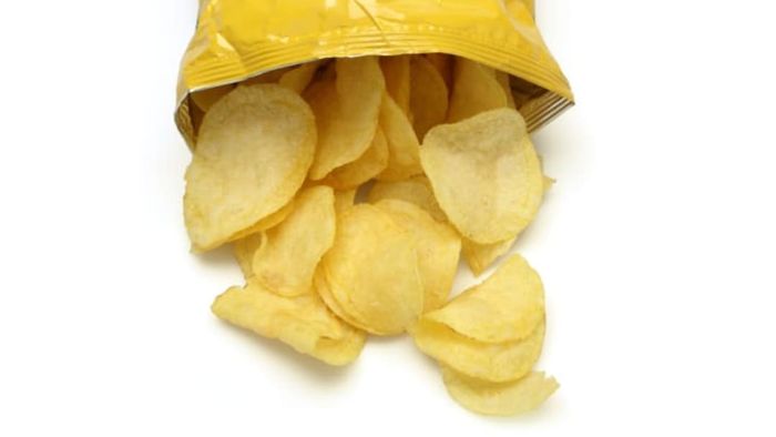 A bag of potato chips opened with chips spilling out.