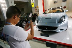 In 2009, a man takes pictures of a Ferrari California during an auto exhibition in Beijing, China. The five-day event showcased a variety of imported cars, many of which were high-end luxury models.