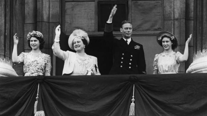 From left to right: Princess Elizabeth, Queen Elizabeth, King George VI, and Princess Margaret Rose wave from the balcony of Buckingham Palace on VJ Day, August 15, 1945, in London, England.