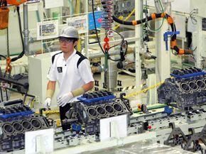 A worker is seen assembling vehicles on the production line at Toyota Motor Corp in Japan.