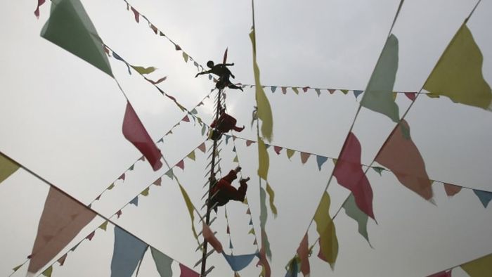 Miao performers demonstrating their skills on traditional knife ladders