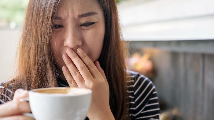 A woman inhaling the aroma of coffee