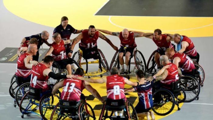 A team of athletes gathers in a huddle during the Invictus Games