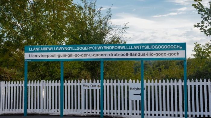 A sign at the train station helps with pronouncing the 58-character-long name of this Welsh town.