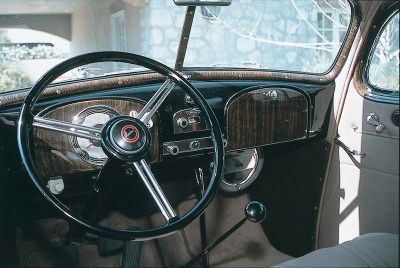 The 1935 Pontiac dashboard showcased a woodgrained instrument panel, emphasizing a perfectly symmetrical design.