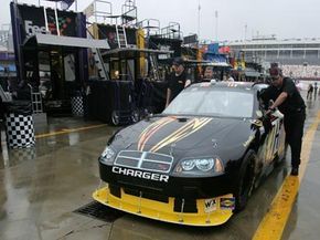 Crew members at the Nextel Sprint Cup Series Bank of America 400 had to push cars out of the garage after a rain delay led to the cancellation of both qualifying and practice sessions.