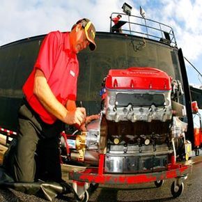 A member of the crew gets an engine ready for a NASCAR race.