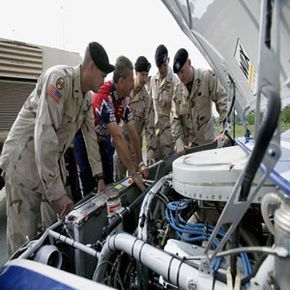 Doug Richert, the crew chief for Roush Racing, explains the design and performance of NASCAR engines to members of the North Carolina National Guard.