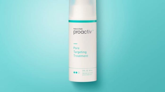 A bottle of Proactiv solution placed on a blue background