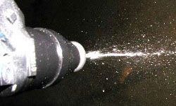 A fuel injector delivering gasoline directly into an engine.