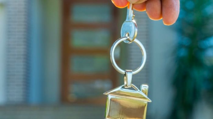 A person transferring the keys to a house.