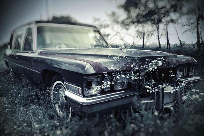 An old hearse with malfunctioning headlights