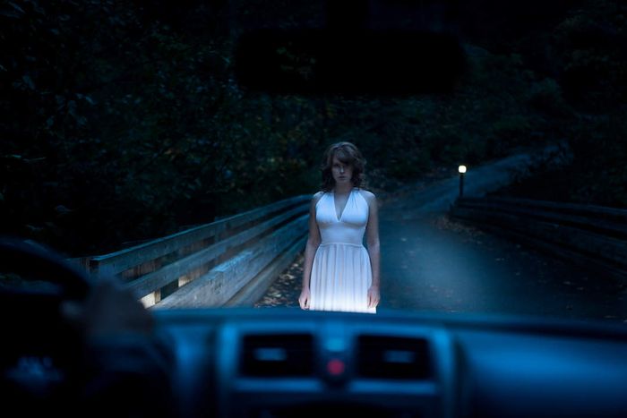 Ghostly Woman Standing on Road in Car Headlights
