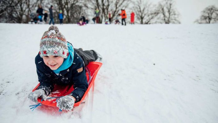 This kid might be conquering the hill, but he's not using a sleigh.