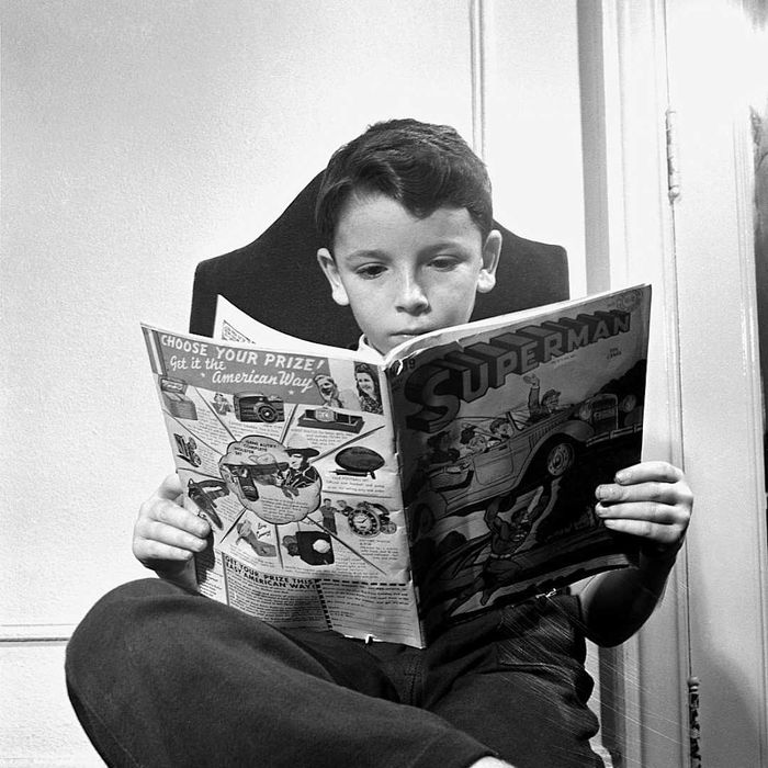 A child is shown holding a 'Superman' comic.