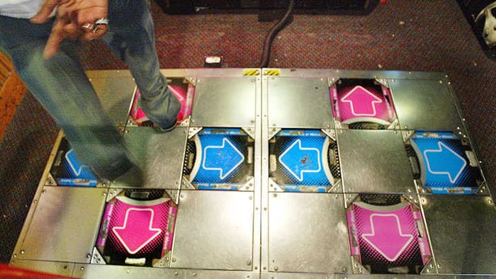 A gamer grooves on the DDR or Dance Dance Revolution gaming platform.