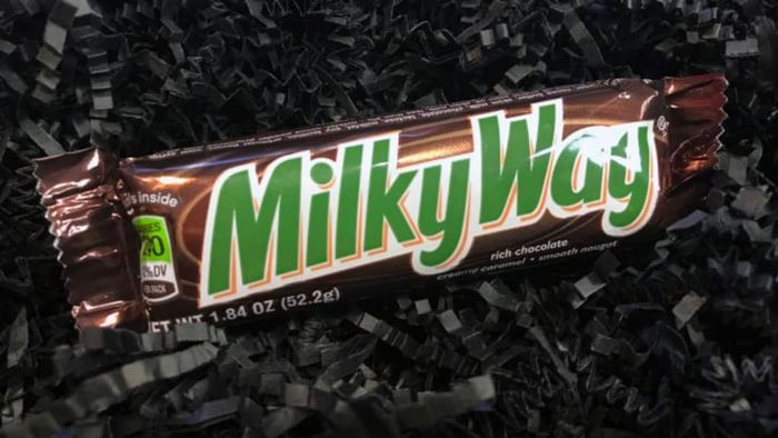 A Milky Way bar placed on a dark background.