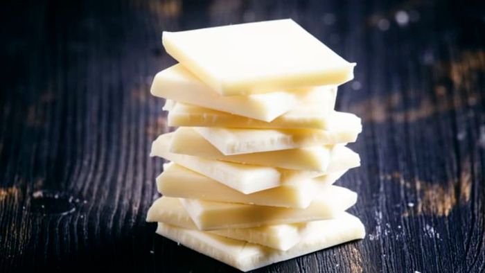 Pieces of white chocolate neatly stacked in a pile.