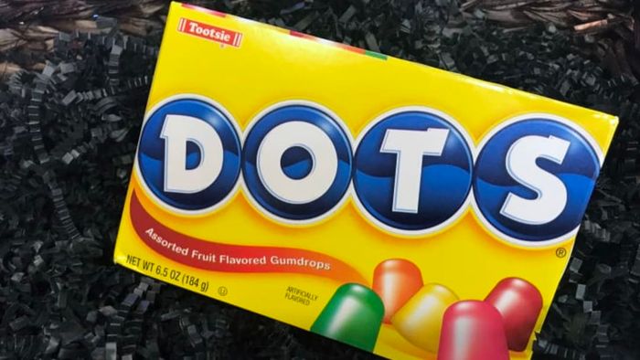 A box of DOTS gumdrops placed on a dark background.