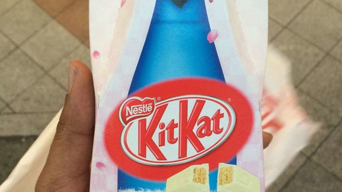 A person holding a pack of sake-flavored Kit Kats.