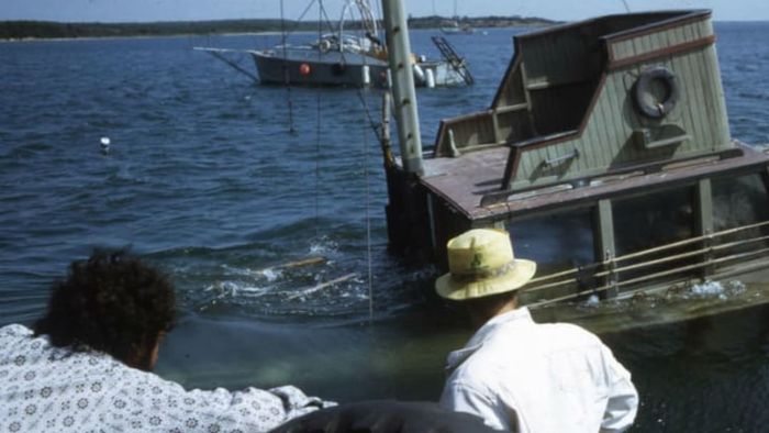 Joe Alves (L) and another crew member watch as the Orca II sinks as planned.