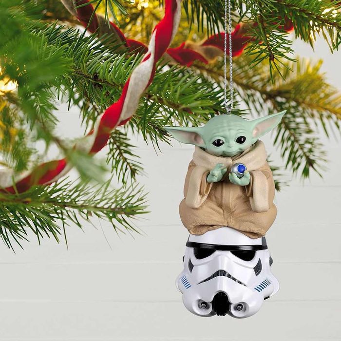 Christmas ornament featuring Baby Yoda sitting on a stormtrooper helmet