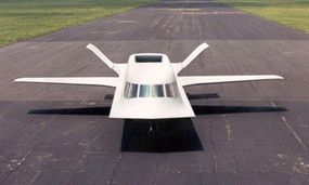 The white aircraft Tacit Blue rests on a runway, poised for flight.