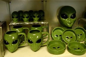Alien-themed mugs and bowls on display at a gift shop.