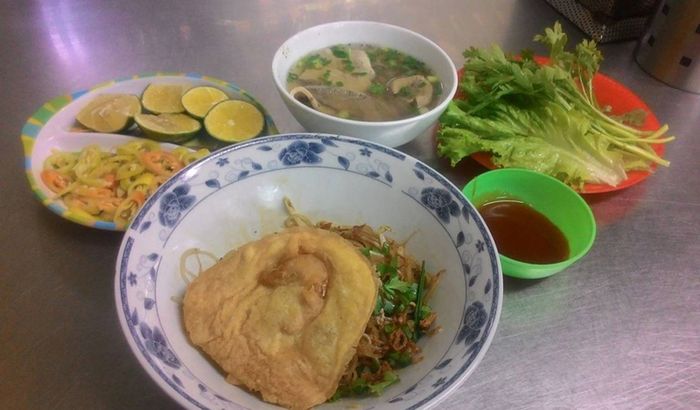 Hình ảnh tô hủ tiếu đầy đặn với mực, thịt viên và trứng cút tại A Hòa