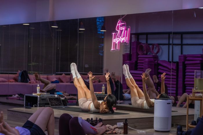 Học viên đang thực hành yoga cùng huấn luyện viên chuyên nghiệp