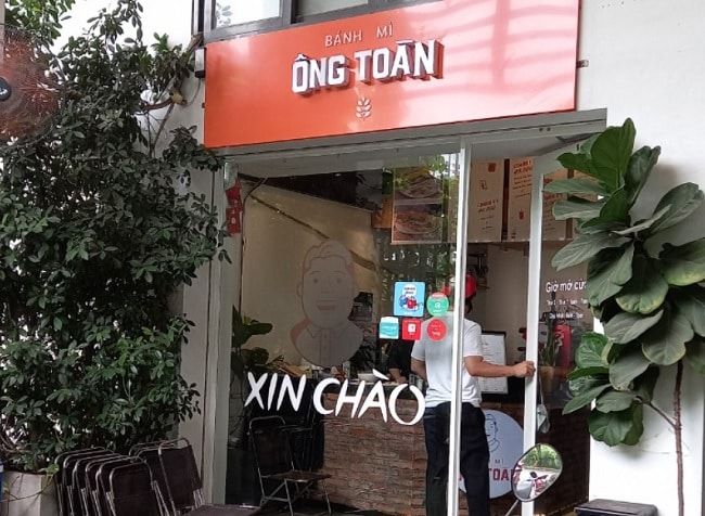 Bánh mì Ông Toàn – Nơi bạn có thể thưởng thức những ổ bánh mì với hương vị độc đáo, kết hợp cùng các loại topping như pate, chả lụa và thịt khìa, làm phong phú thêm thực đơn sáng của bạn. Không gian thoáng đãng và dịch vụ nhanh chóng, phù hợp cho những ai yêu thích sự tiện lợi.