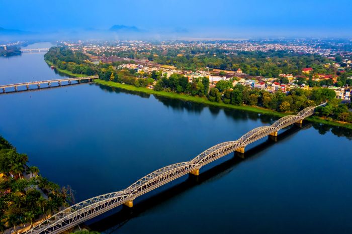 Huế ảnh 1 - Bình minh trên sông Hương với sương sớm giăng mắc nhẹ nhàng, phía xa tháp chùa Thiên Mụ cổ kính in bóng trên nền trời hồng rực.