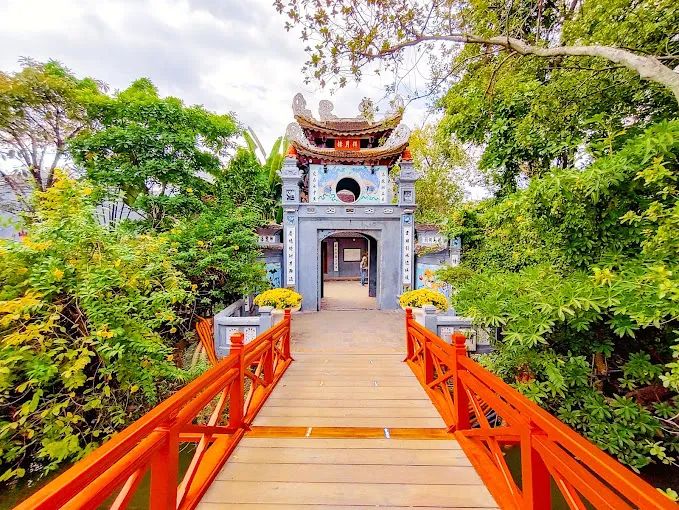 Ảnh chụp toàn cảnh Đền Ngọc Sơn - kiến trúc cổ kính soi bóng xuống mặt hồ Gươm trong xanh, nối liền bờ bằng cây cầu Thê Húc cong cong như dải lụa đào.