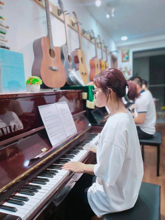 Giảng viên và học viên trong giờ học piano tại HP Music