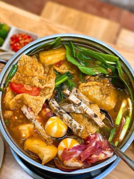 Lẩu Lai Zai Tùng Béo ảnh 2 - Góc nhìn cận cảnh về những viên thả lẩu đặc biệt, thịt bò tươi mềm và đậu hũ vàng ruộm đang bồng bềnh trong nước lẩu chua thanh.