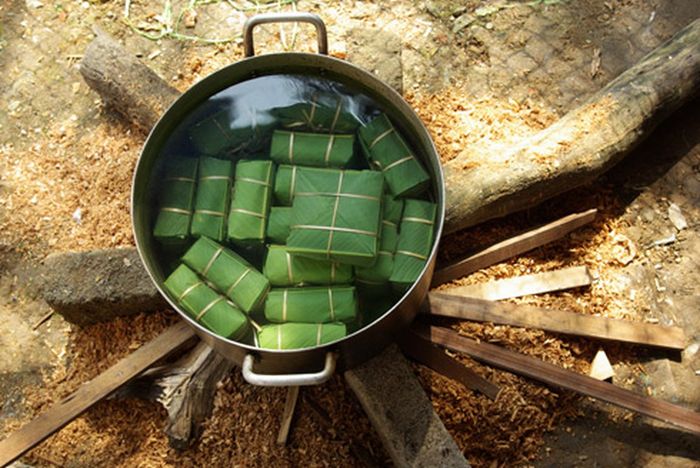 Hình ảnh minh họa số 1: Bánh chưng xanh truyền thống với lá dong tươi, dây lạt buộc đỏ rực rỡ - Nguồn: Internet
